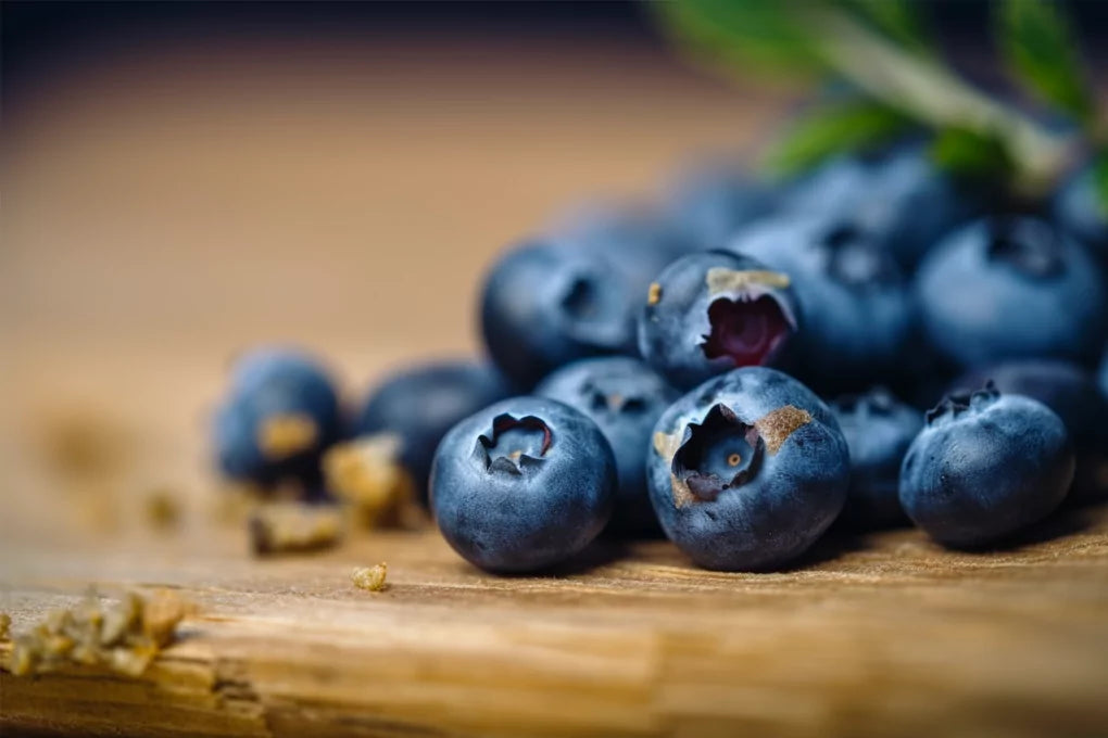 Blueberries scattered across a wooden surface
