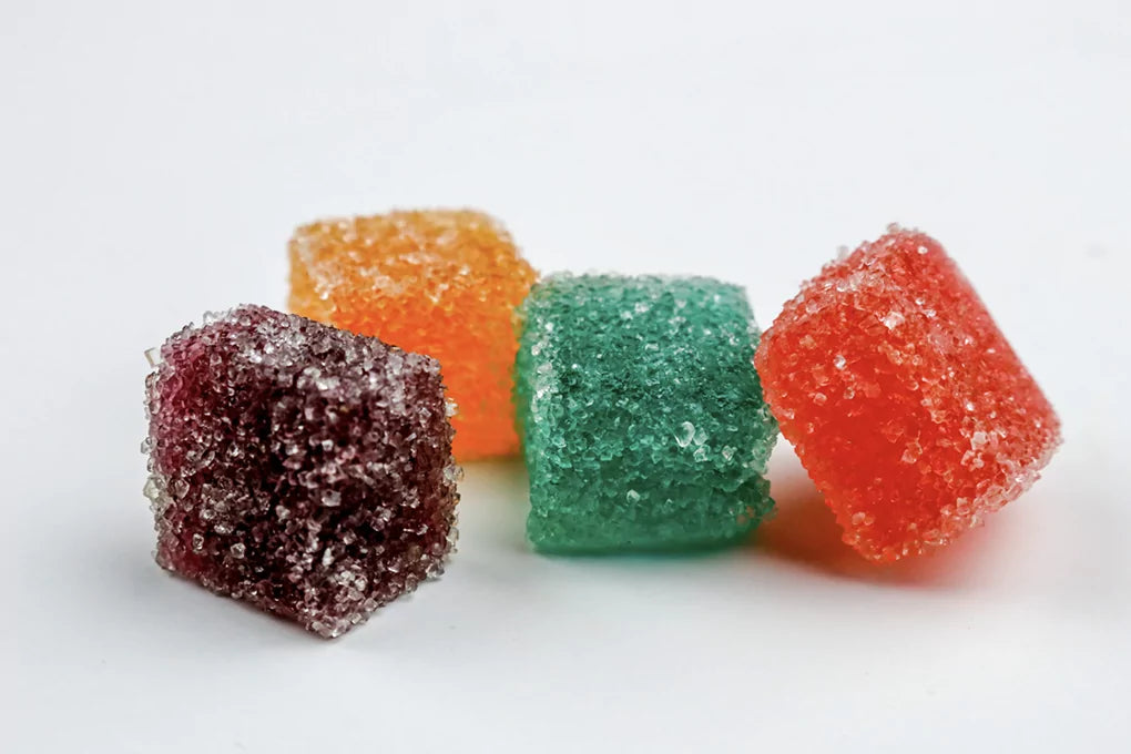 A close up of Botany Farms gummy candies in various colors, and loaded with edible terpenes.