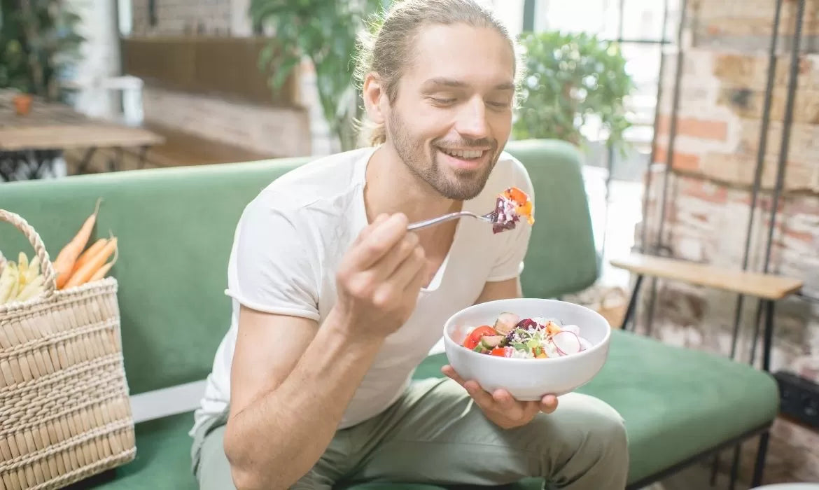 Man eating a vegetables bowl after smoking a strain for appetite stimulation