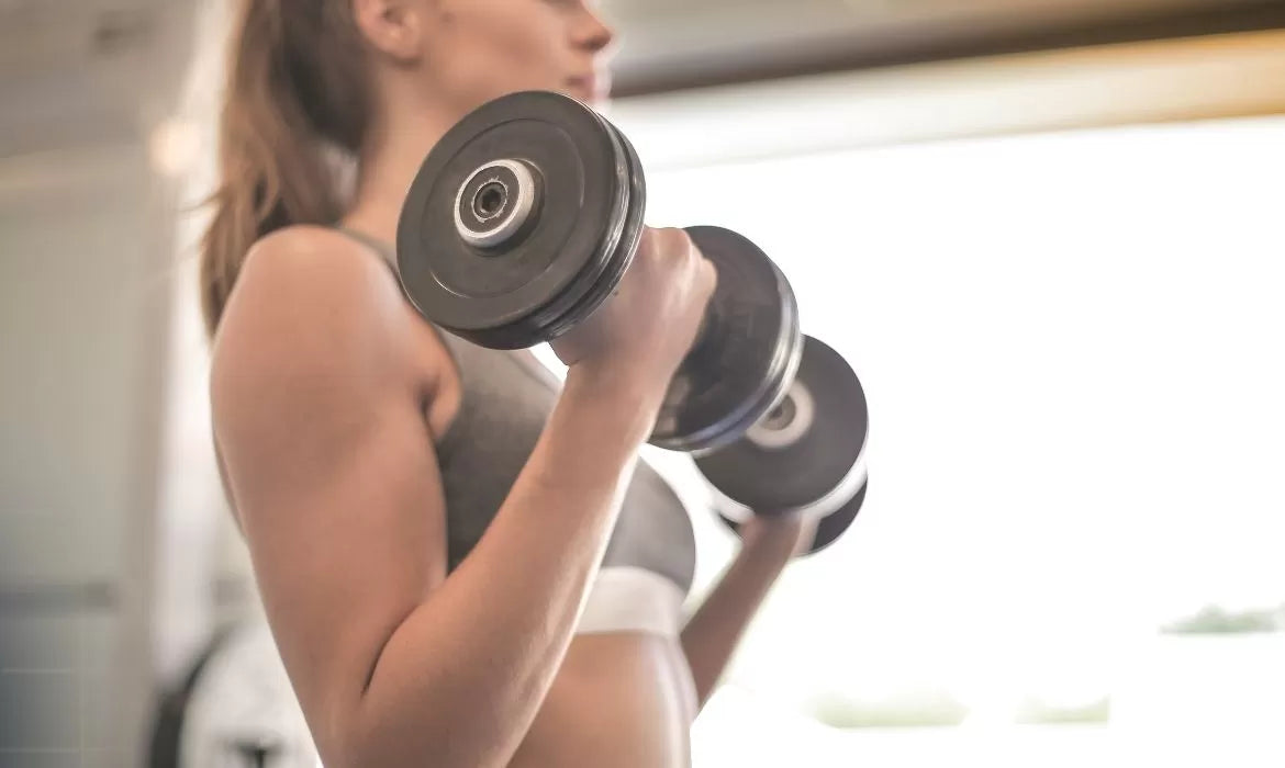 Woman lifting weights before taking CBD after workout