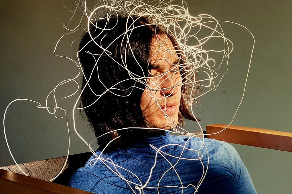 Woman in chair, eyes closed, head wrapped with white wire, expressing brain fog and fatigue