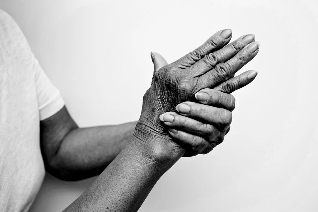 A black and white picture of a person wringing their hands to relieve them from arthritis.