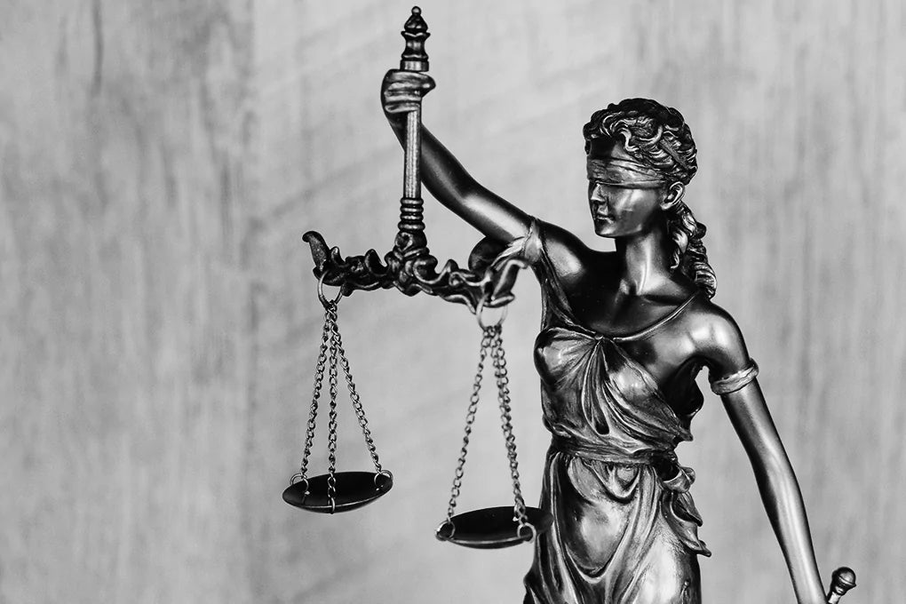 A silver statue of blind justice holds a pair of scales. Are Delta-9 THC gummies legal in Minnesota?