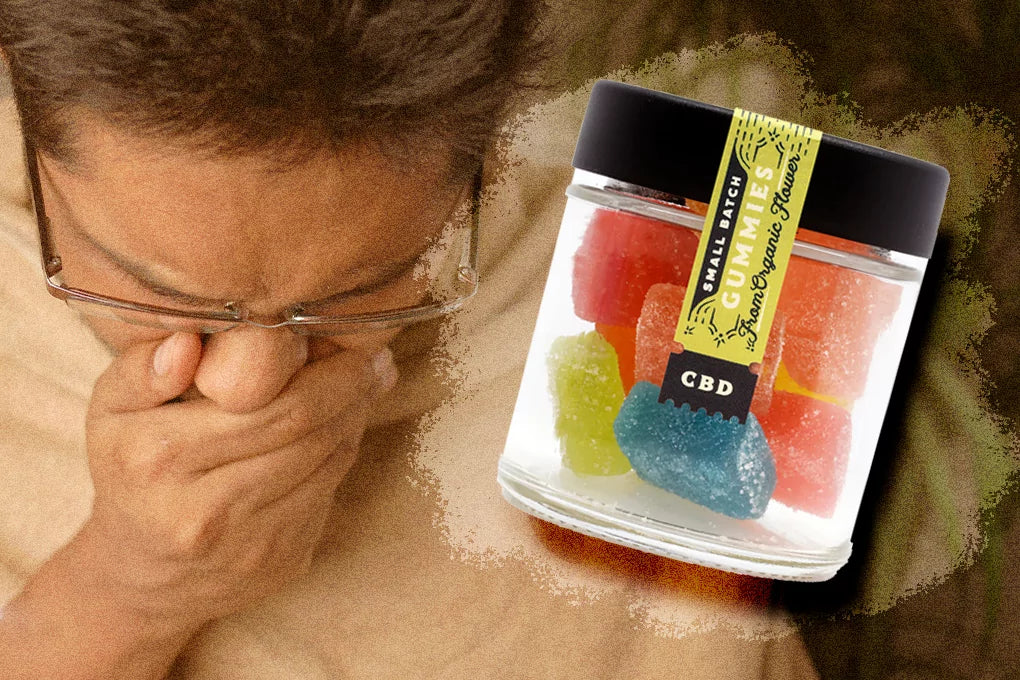 CBD small batch gummies from organic flower in a glass jar with a man reacting to a strong scent by covering his nose and mouth with his hands