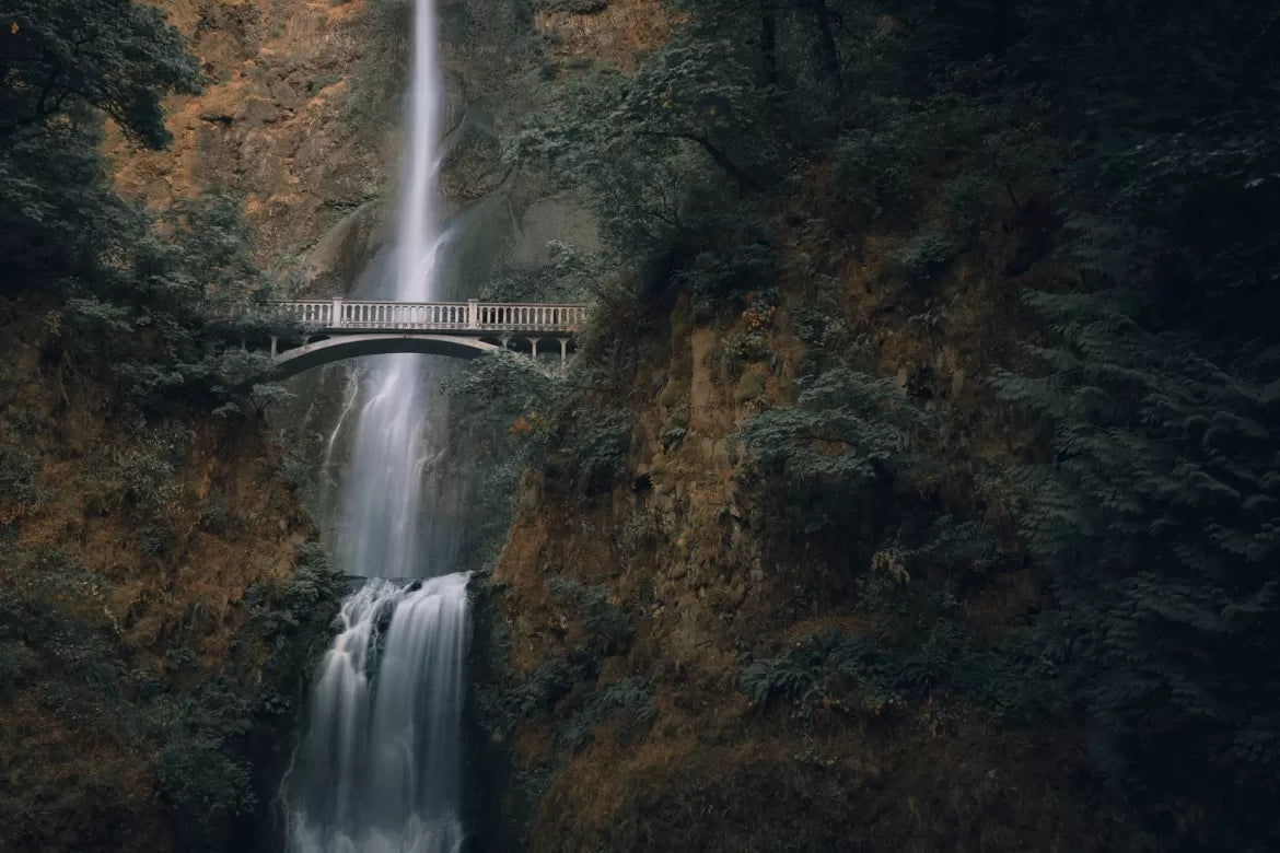 A beautiful bridge in Oregon, is over top of a cascading waterfall.