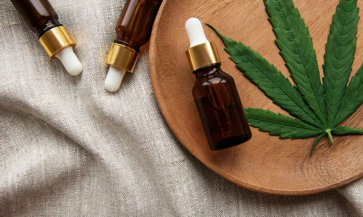CBD tinctures next to a hemp leaf
