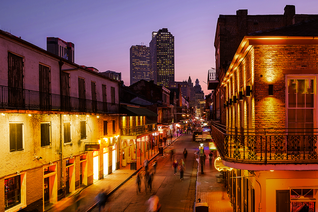 A beautiful evening view of New Orleans City in Louisiana, with street lights shining and people walking on the street