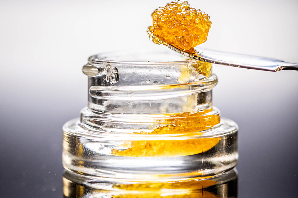 Cannabis Live Resin extracted from a vial using a butter knife, displaying its rich texture and vibrant colors