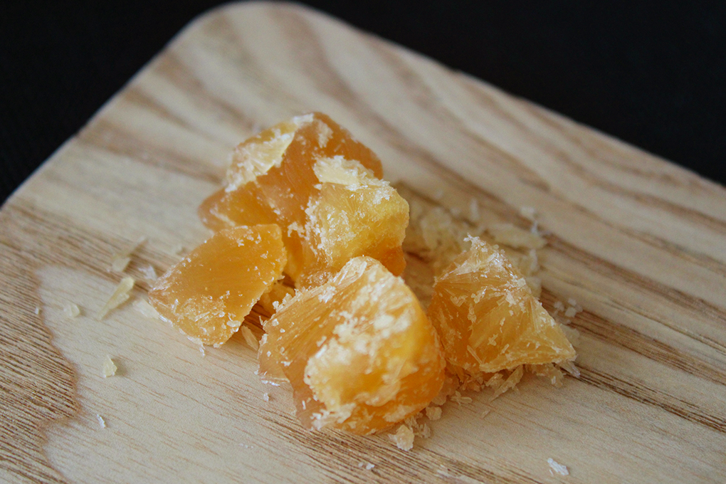 Several yellow-colored live rosin are placed on a wooden surface