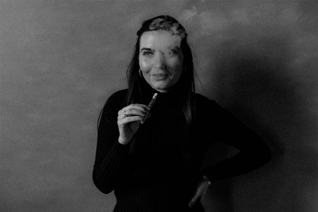 A black and white image of a woman smoking a delta-8 vape.