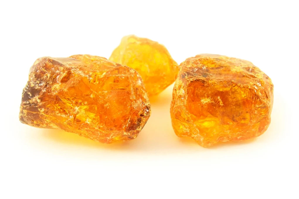 3 pieces orange colour Live Rosin on a white surface