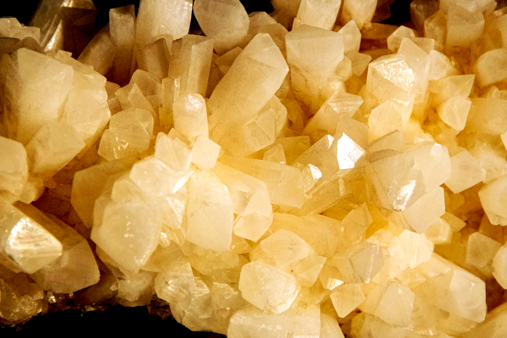 Some white glossy cannabis diamonds are placed on a black surface