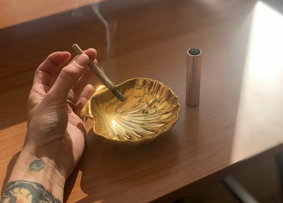 A hemp flower joint being smoked by an ashtray