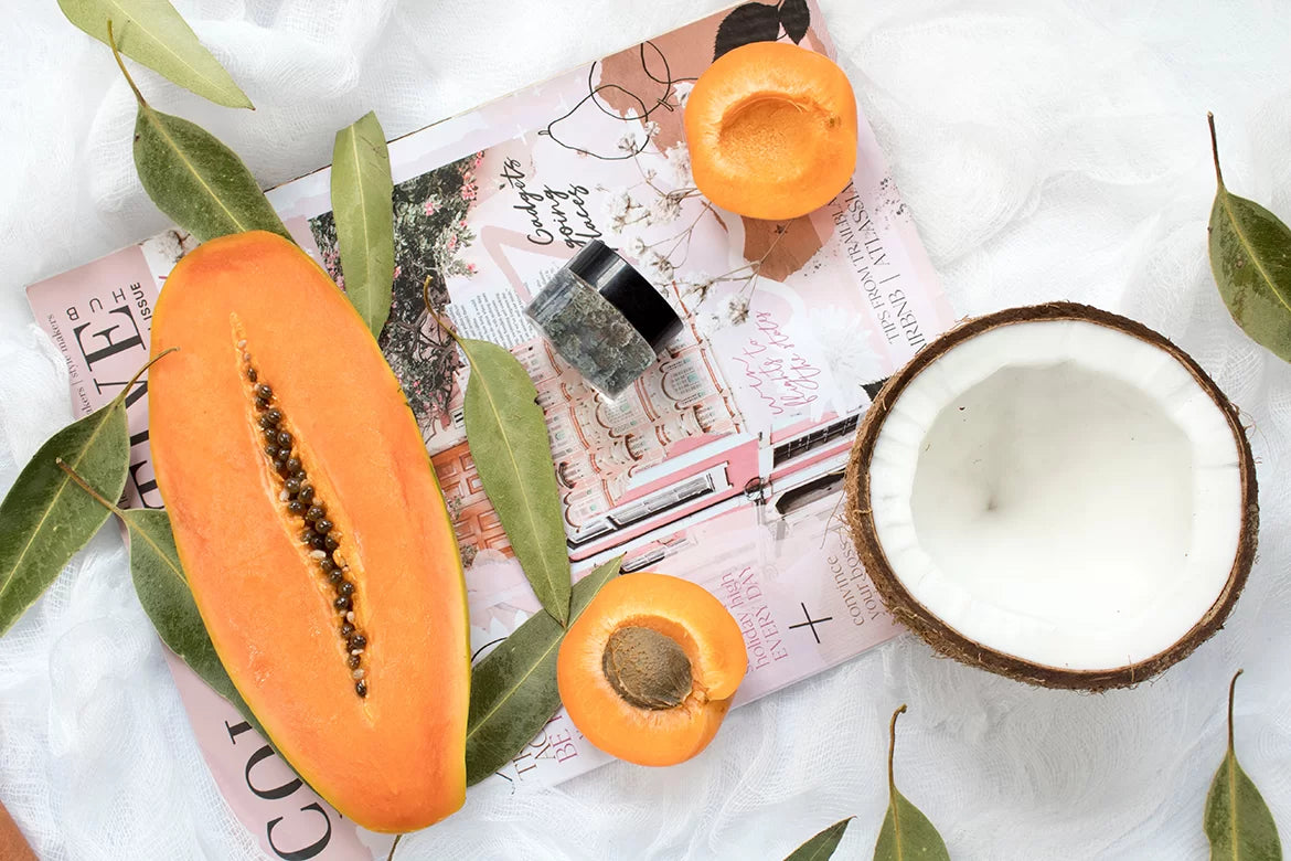 A jar of Golden Papaya cannabis next to a Papaya sliced up