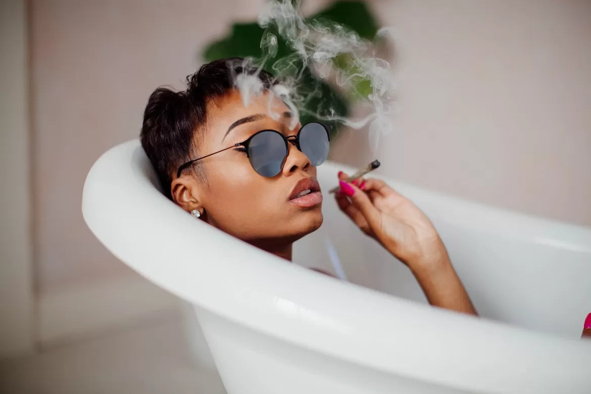 A woman smoking a pre-roll in the bath