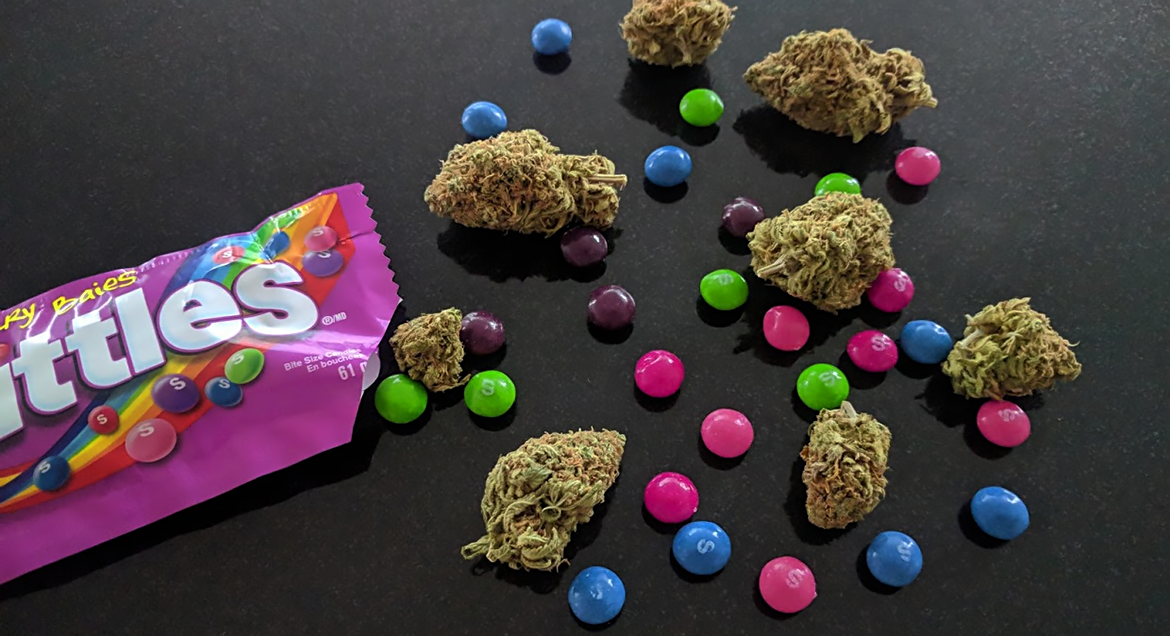 Purple Skittles cannabis flower near some actual Skittles candy
