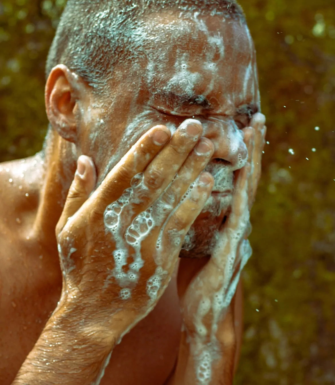 A man using hemp body wash on his face and hands