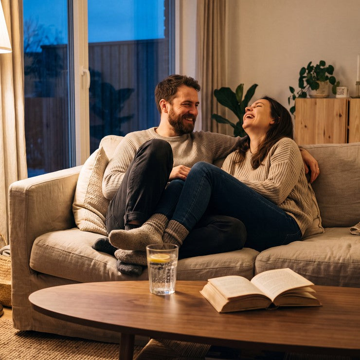 A couple relaxing on a sofa in the evening